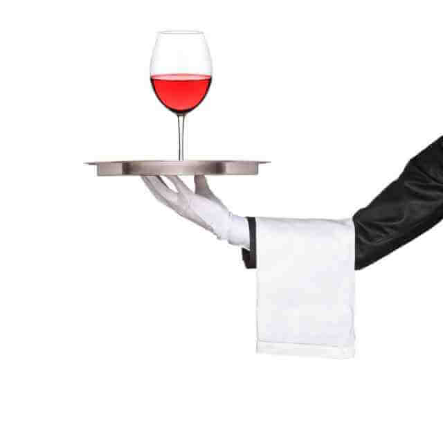 Butler holding glass of wine on a tray.